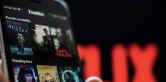 Ręka trzymająca telefon z aplikcją Netflix