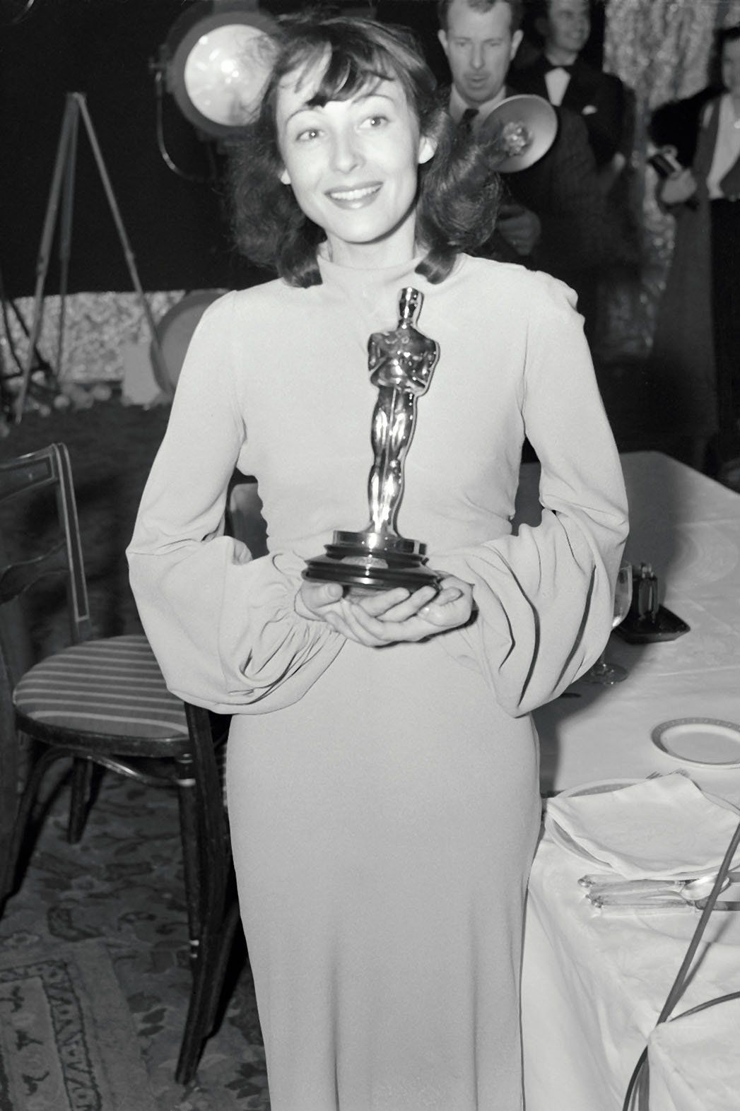 Czarno-białe zdjęcie kobiety w sukni pozującej z Oscarem
