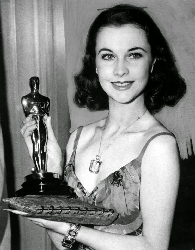 Czarno-białe zdjęcie kobiety w ciemnych włosach z Oscarem w ręku