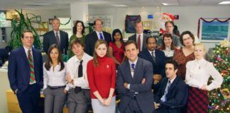Grupa ludzi z serialu The Office stojąca w biurze