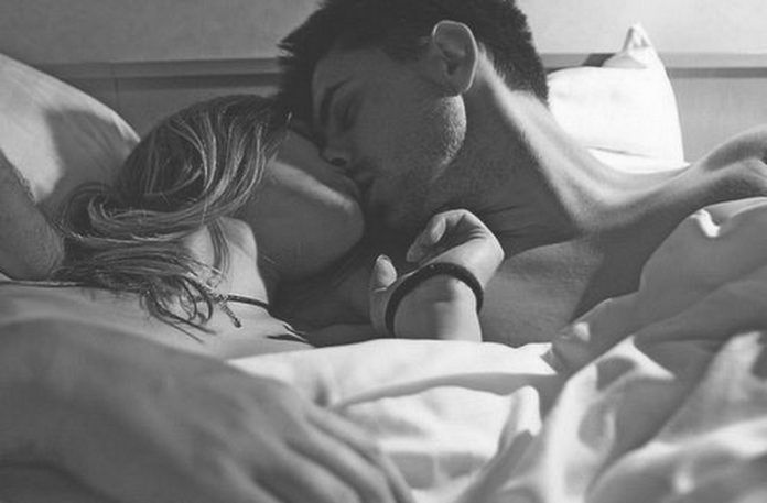 Czarno-białe zdjęcie pary całującej się w łóżku