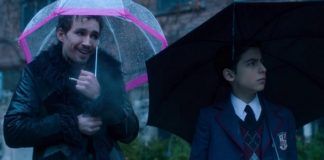 Mężczyzna z różowym parasolem i chłopiec obok z czarnym parasolem