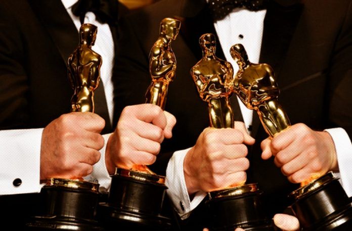 Cztery dłonie trzymające Oscary