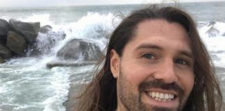 Mężczyzna z długimi włosami na tle morza