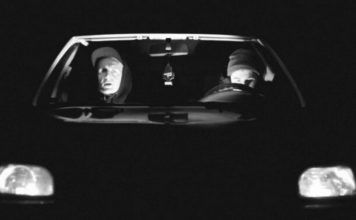 Dwóch mężczyzn w czapkach w czarnym samochodzie
