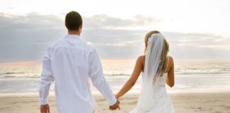 Para nowożeńców spacerująca plażą