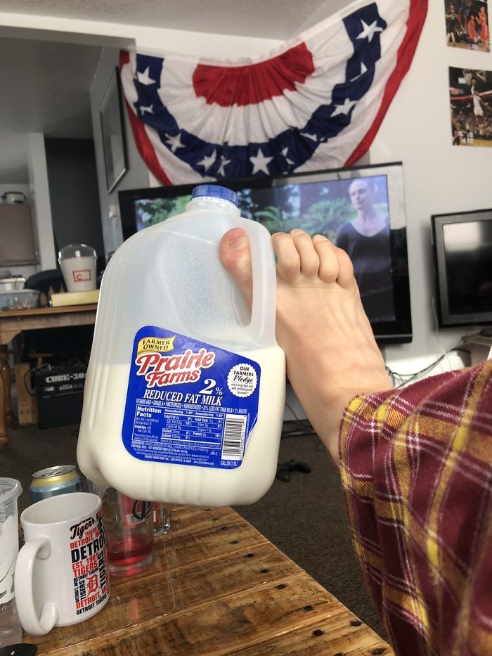 Pudełko z mlekiem trzymane stopą