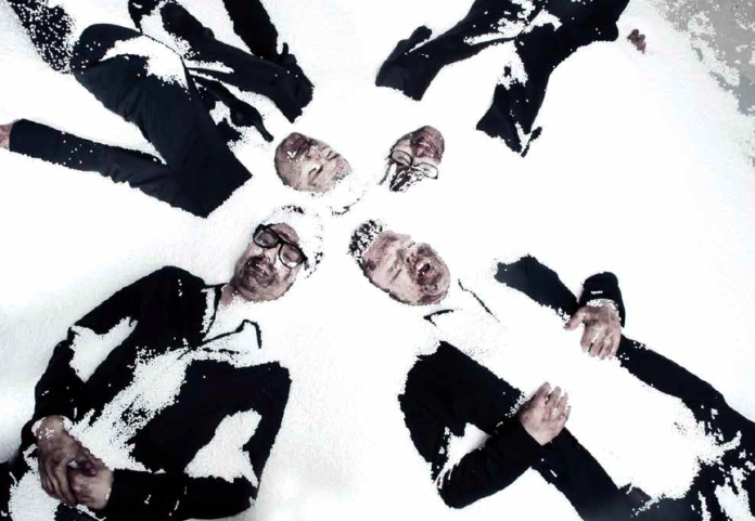 Zespół Muchy - zdjęcie na śniegu, mężczyźni ubrani w garnitury.