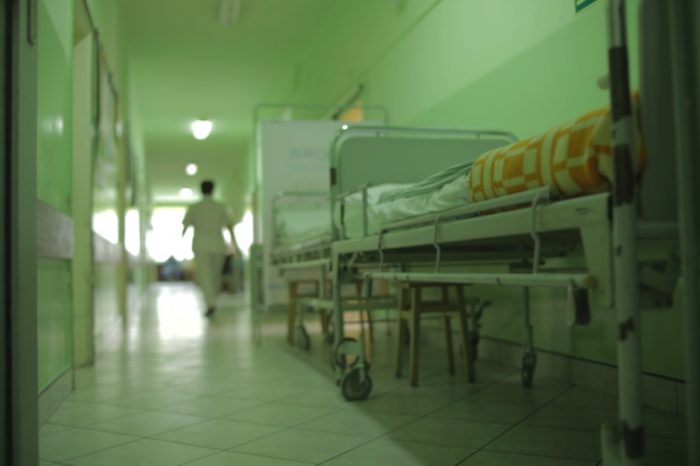 zdjęcie przedstawia łóżko szpitalne i korytarz 