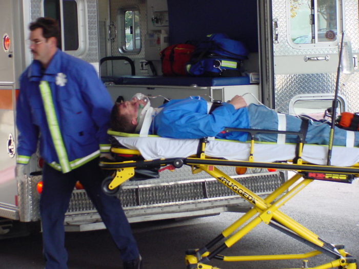 ratownik medyczny przewozi rannego na noszach 