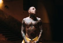 Chłopak z gołą klatką piersiową pokrytą tatuażami
