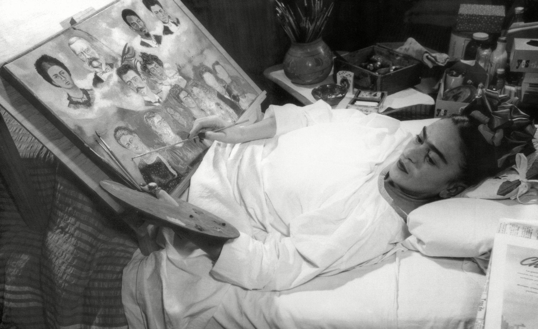 Kobieta leżąca na łóżku, malująca obraz