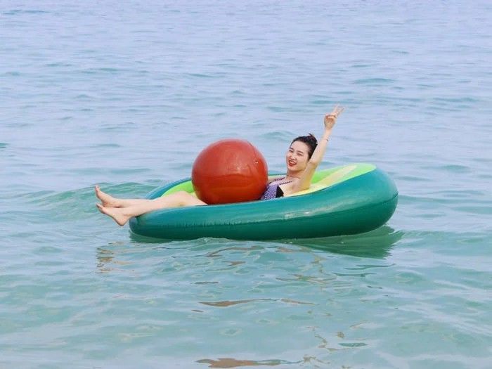 ponton w kształcie awokado na morzu z dziewczyną w środku
