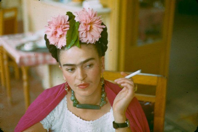 Kobieta z papierosem w dłoni i kwiatach na głowie