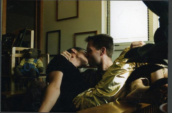 Dwóch mężczyzn całujących się na kanapie
