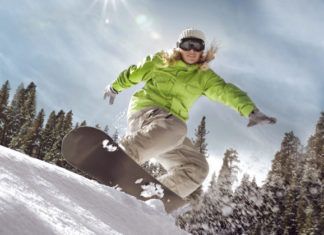 Dziewczyna w zielonej kurtce na snowboardzie