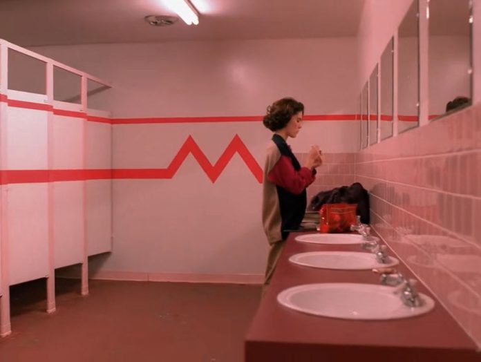 wnętrze łazienki i dziewczyna stojąca przy lustrze