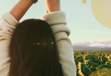 Dziewczyna odwrócona od obiektywu, patrząca na pole słonecznikow