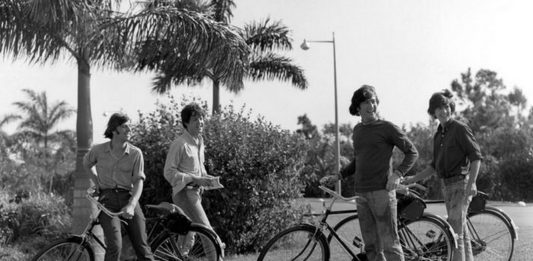 Czarno-białe zdjęcie cztererch mężczyzn na rowerach