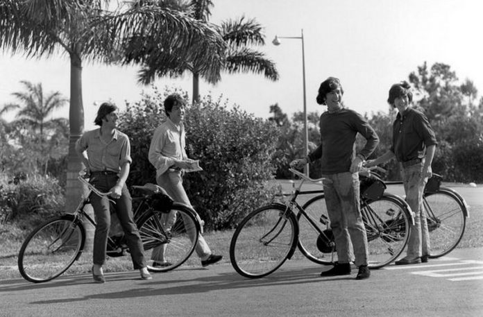 Czarno-białe zdjęcie cztererch mężczyzn na rowerach