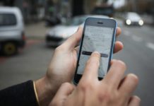 Dłoń trzymająca smartfon z otwartą aplikacją Uber