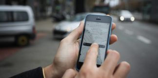 Dłoń trzymająca smartfon z otwartą aplikacją Uber