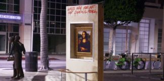 Obraz Mony Lisy zawieszony w betonowej ścianie na środku ulicy