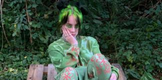 Dziewczyna ubrana na zielono, w zielonym ubraniu, siedząca na tle krzaków
