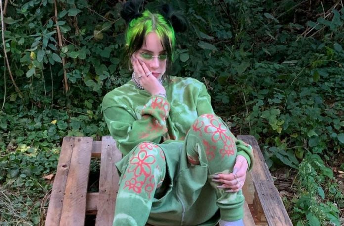 Dziewczyna ubrana na zielono, w zielonym ubraniu, siedząca na tle krzaków