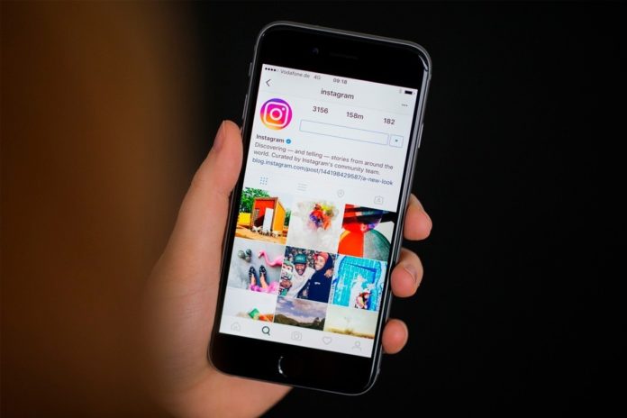 Dłoń z telefonem i otwartą aplikacją Instagram