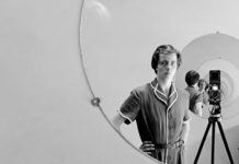 Czarno-białe zdjęcie kobiety stojącej przy lustrze