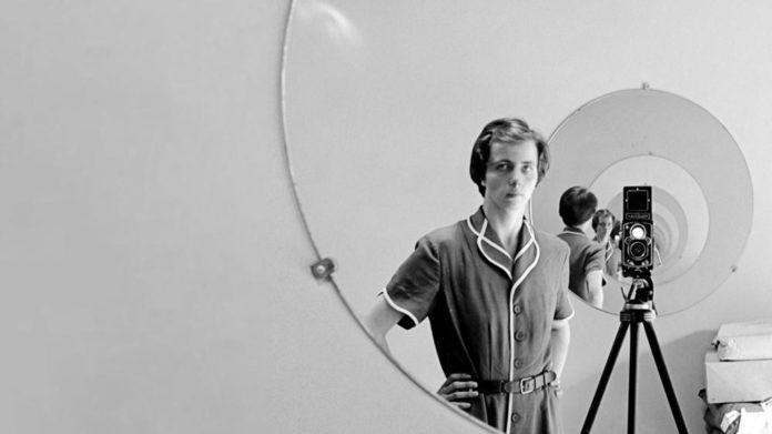 Czarno-białe zdjęcie kobiety stojącej przy lustrze
