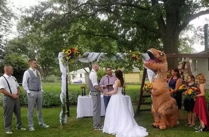 Para biorąca ślub i dziewczyna w stroju dinozaura