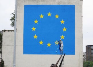 Flaga Unii Europejskiej i mężczyzna odłupiający jedną gwiazdę