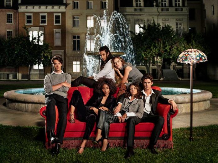 Grupa ludzi siedzaca na kanapie przy fontannie
