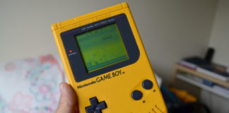 Dłoń trzymająca żółtego GameBoya