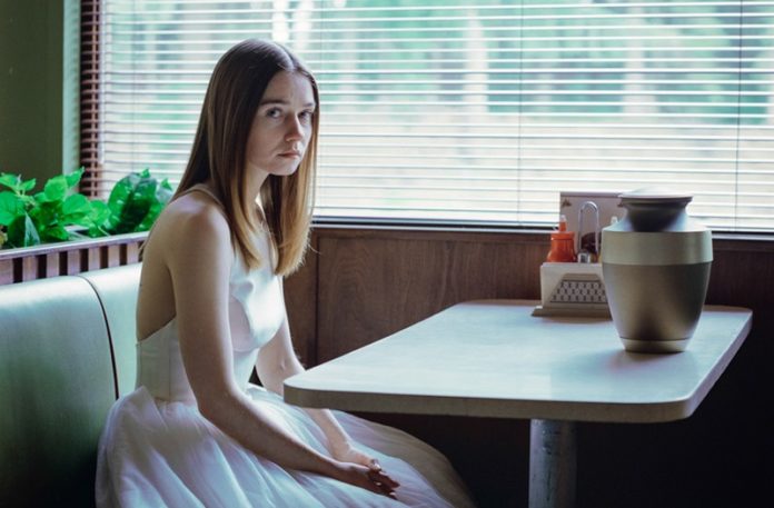 Dziewczyna w białej sukience siedząca w restauracji