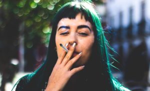 dziewczyna z zielonymi włosami pali papierosa