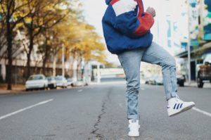 Moda uliczna chłopak w jeansach i sneakersach