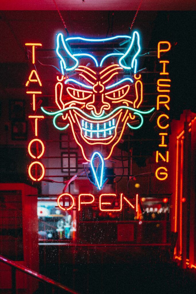 Neon przed wejściem do salonu tatuażu i piercingu