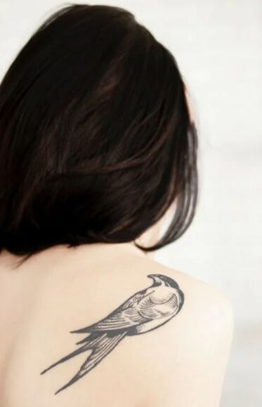 Kobieta z tatuażem jaskółki na plecach
