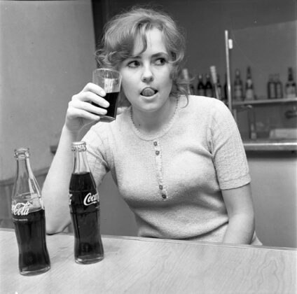 Dziewczyna rozkoszuje się smakiem Coca Cola