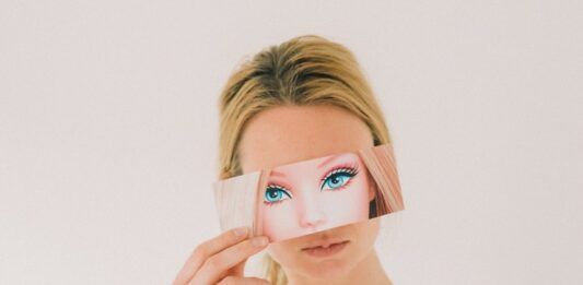 Kobieta trzymająca kartkę z twarzą Barbie