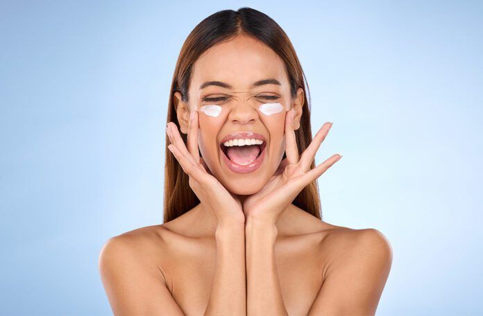 Jak ochronić skórę przed działaniem promieni UV kobieta z kremem na twarzy